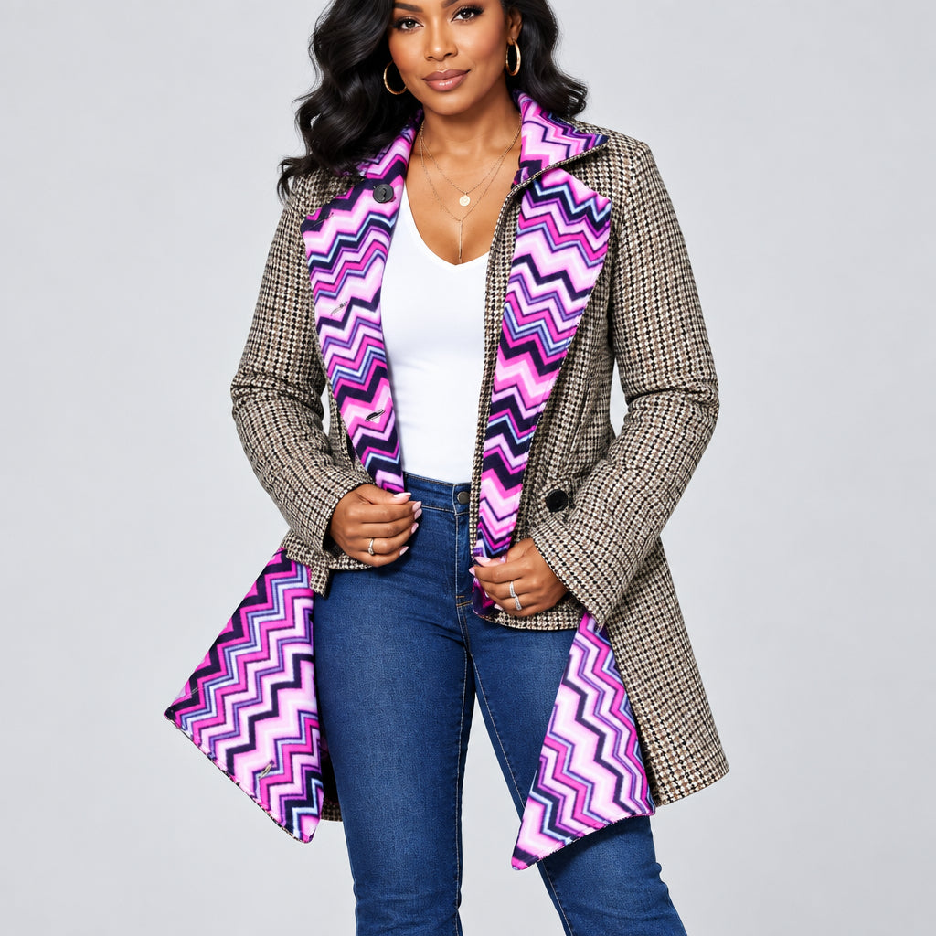 A woman wearing a beige and black houndstooth jacket with bright pink, purple, and black chevron patterned lining, styled with a white top and blue jeans against a white background.